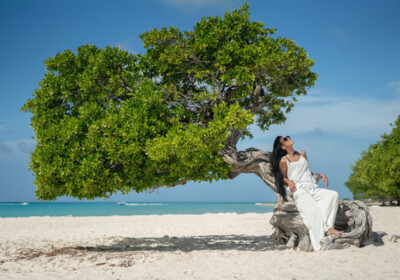 Woman reclining on a divi-divi tree in Aruba